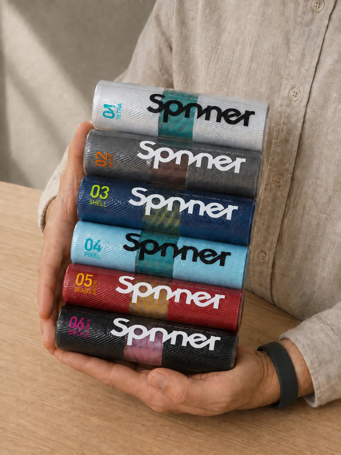 Real-life photo showing all six TENGA Spinner boxes held together in two hands. — TENGA Spinner review product evaluation