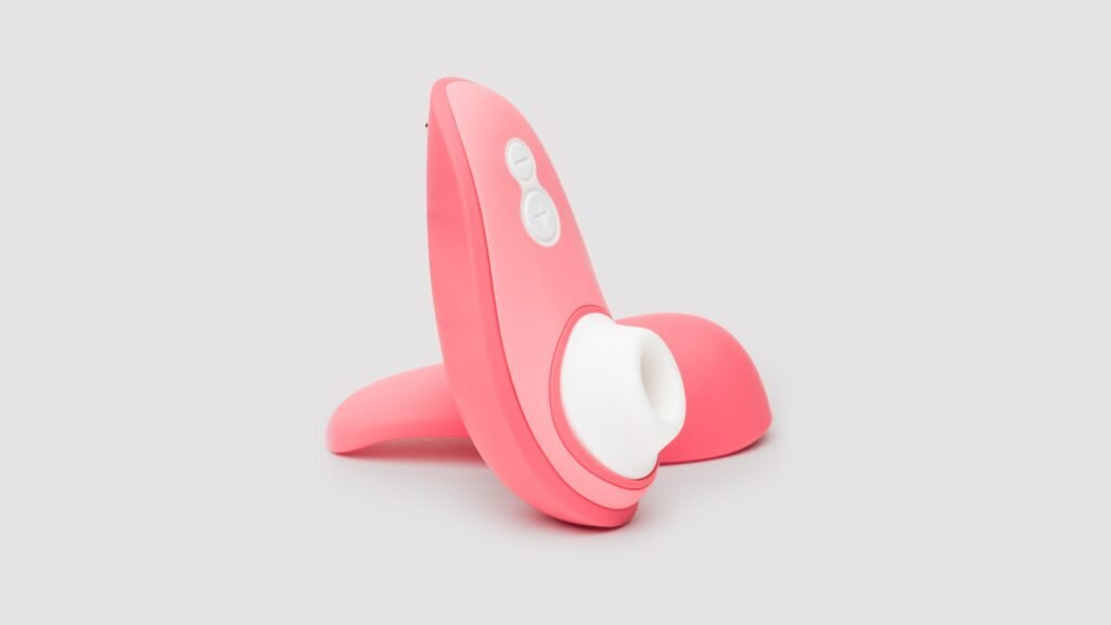 Authentic studio photograph of the Womanizer Liberty 2 clitoral stimulator upright with Pleasure Air nozzle and dual buttons on its detached magnetic travel cap